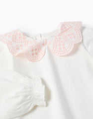 Detalle del cuello rosa con diseño floral tipo ojalillo