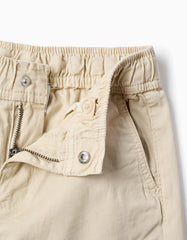 Detalle de cierre y botón en pantalón beige infantil