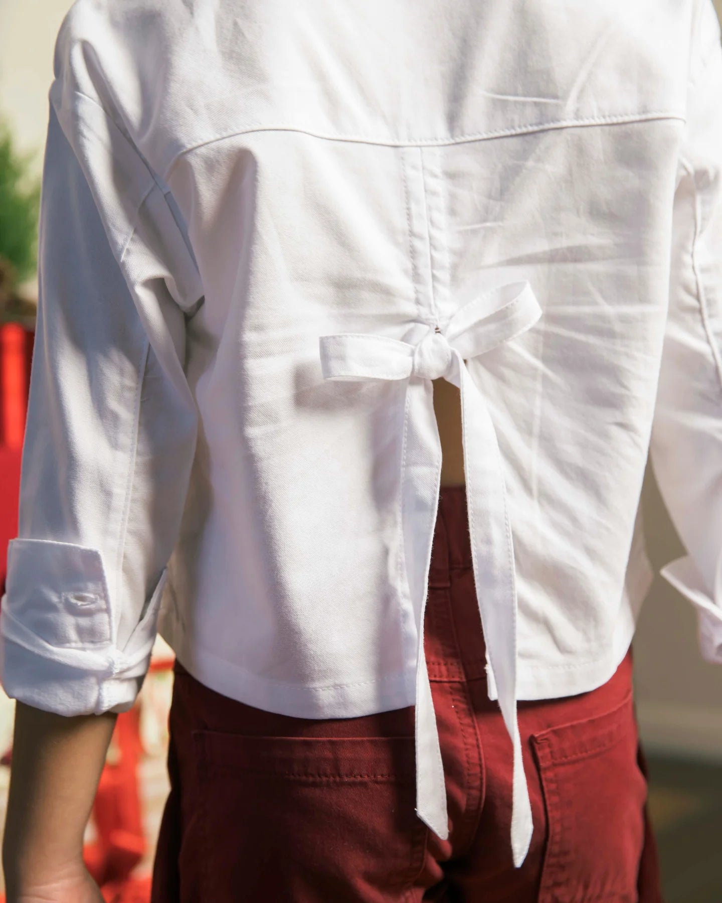 Detalle de moño decorativo en camisa blanca para niña