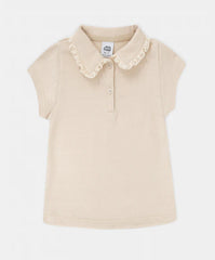 Detalle del encaje en el cuello de blusa beige niña