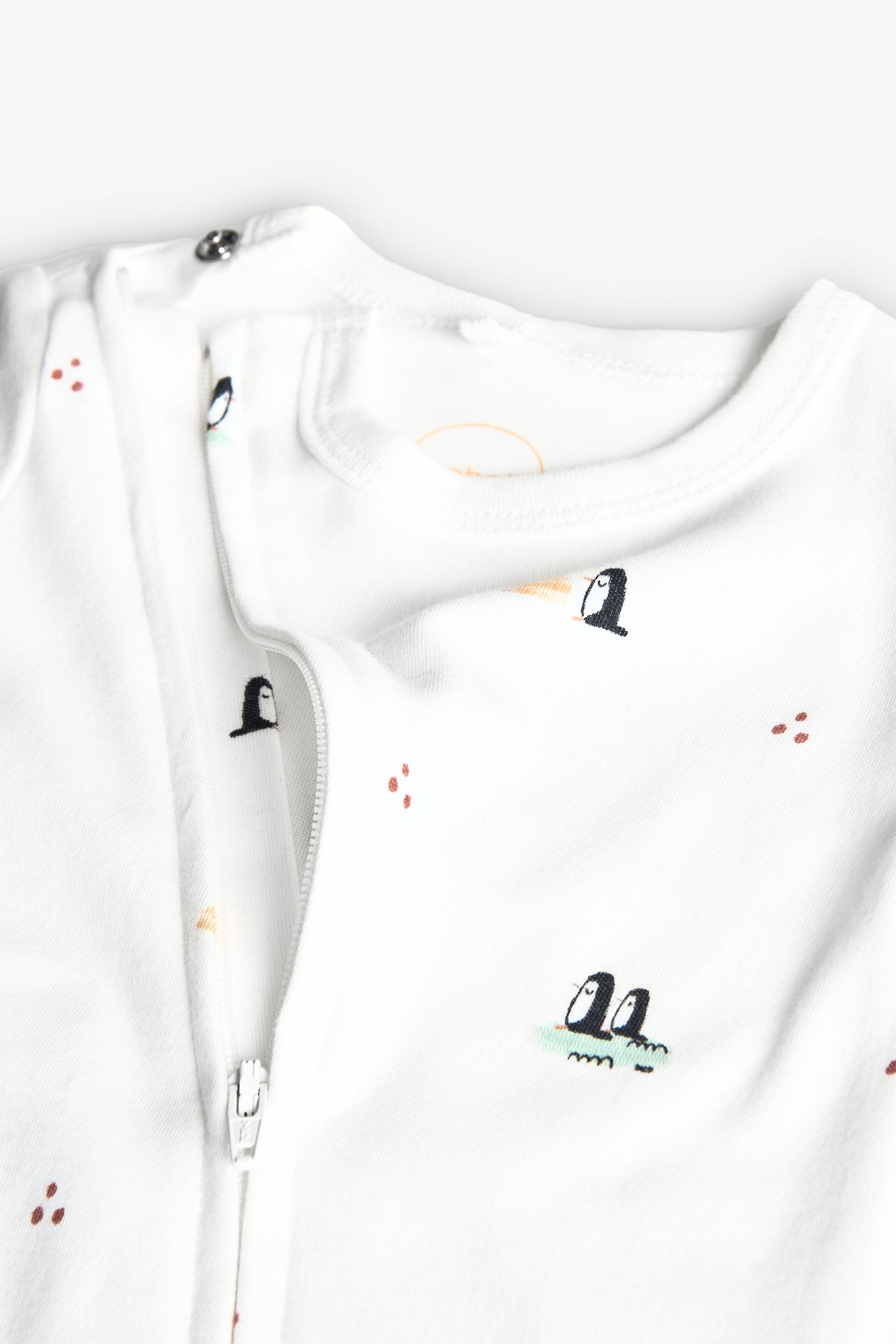 Detalle cierre lateral de pijama blanco para bebé